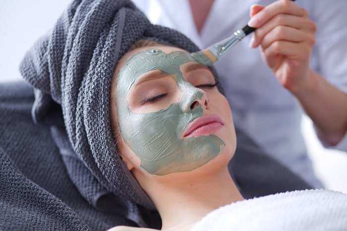 Femeie la salon i se aplica masca cosmetica pe ten