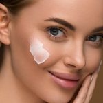 close-up femeie cu ten curat si crema pe față