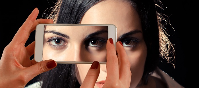 detaliu ochi femeie poza cu smartphone