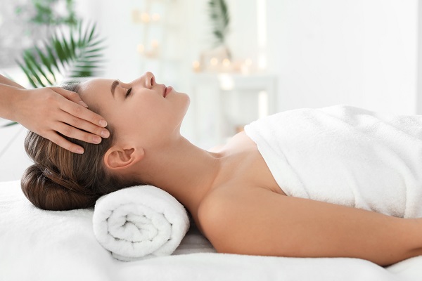 Tânără care se bucură de masaj în salonul spa.