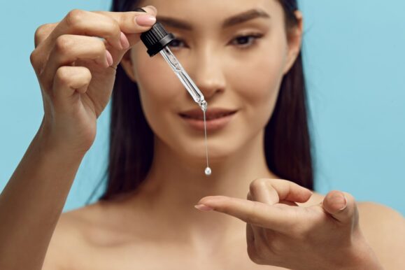 femeie cu un produs cu retinol in mana 