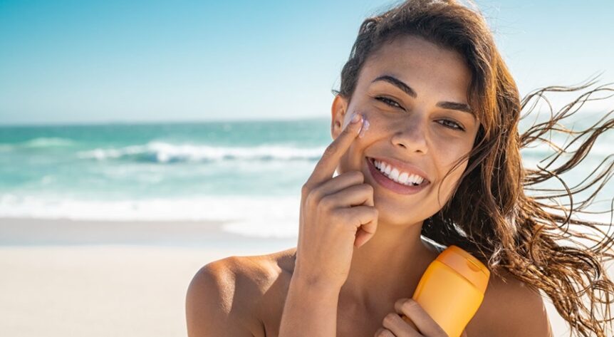 femeie pe plaja cu protectie solara